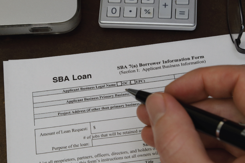 Closeup view of a businessman's hand filling SBA Loan From