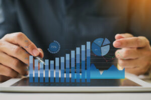 A businessman performs cash flow management with a digital display of financial data and analytical graphs.